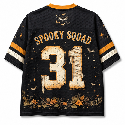 Back view of a black short-sleeve jersey with 'SPOOKY SQUAD' and the number '31' in a cracked beige stone texture, decorated with orange and white sleeve stripes, a bat graphic, stars, and autumn leaves.
