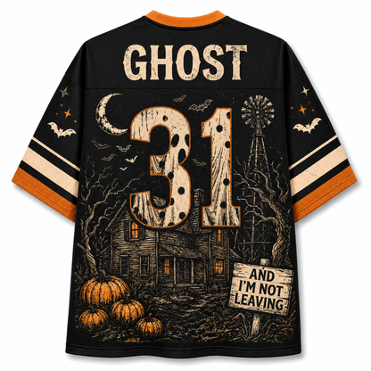 A black short-sleeve jersey shown from the back, featuring a distressed Halloween graphic with the name GHOST, number 31, a haunted house, pumpkins, bats, a moon, and a sign reading AND I'M NOT LEAVING. The collar and sleeve cuffs are orange.