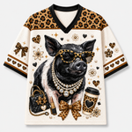 A short-sleeve V-neck jersey-style top with an all-over graphic print. The design features a black-and-white pig wearing leopard-print sunglasses, layered with pearl necklaces, alongside a black quilted handbag, lipstick, a leopard-print bow, and a coffee cup.