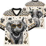 A V-neck short-sleeve shirt shown from the front and back, featuring a large illustrated elephant wearing leopard-print sunglasses, a diamond necklace, and a raised trunk on an off-white background with leopard-print shoulder panels and small decorative motifs.
