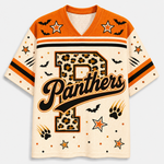 A short-sleeve V-neck jersey-style shirt with orange and cream panels, black and orange stripes, bat silhouettes, stars, paw prints, and a large leopard-print letter P with the word Panthers across the front.