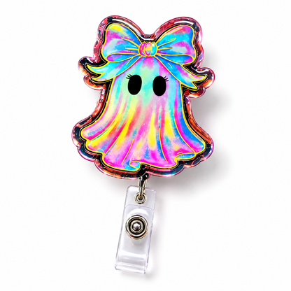 A ghost-shaped retractable badge reel featuring a holographic iridescent finish with a large bow on the head, black eyes, and a clear plastic clip on a white background.