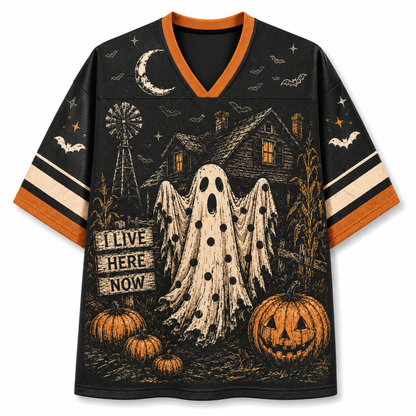 A black V-neck short-sleeve jersey-style shirt with orange trim and a Halloween graphic print featuring a ghost, haunted house, pumpkins, bats, stars, and a moon on a white background.