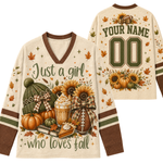 Front and back views of a custom fall-themed football jersey. The cream-colored long-sleeve V-neck jersey features brown trim, green and white striped sleeves, and a detailed graphic of pumpkins, sunflowers, a hot dog, and autumn leaves with the text 'Just a girl who loves fall'.
