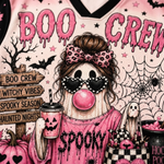 A close-up of a pink Halloween-themed graphic design featuring the words 'BOO CREW' in dripping pink letters, a stylized ghost character with a leopard-print bow, heart-shaped sunglasses, a pink bubblegum bubble, pumpkins, spiderwebs, bats, and a jack-o'-lantern cup.