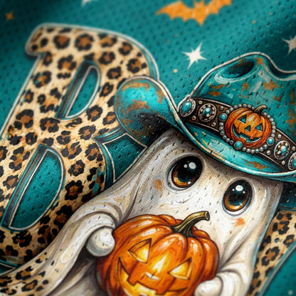 Close-up of a Halloween-themed graphic design featuring a white ghost holding a carved orange pumpkin, wearing a turquoise hat with a jack-o'-lantern emblem, set against a teal textured background with leopard-print lettering and stars.