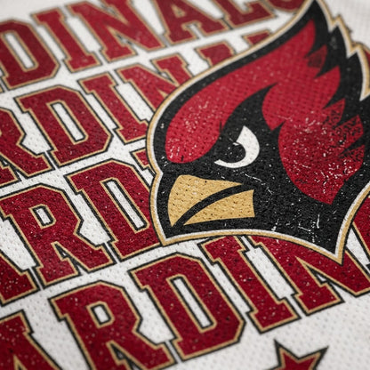 Close-up of a white textured sports jersey featuring the Arizona Cardinals logo and team name in red, black, and gold.