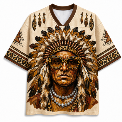 A short-sleeve V-neck jersey-style shirt with a large front graphic of a Native American portrait wearing a feathered headdress and leopard-print sunglasses. The shirt has brown trim, leopard-print sleeve bands, and matching feather and geometric motifs on the shoulders and sleeves.