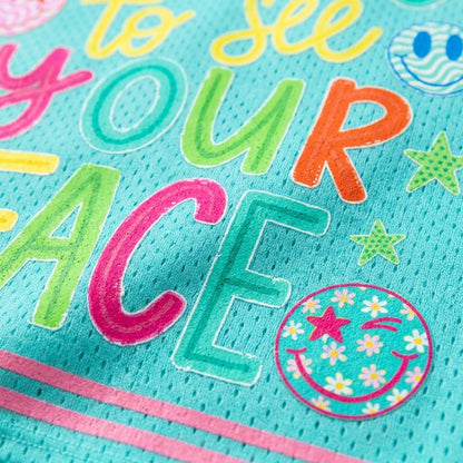Close-up of a turquoise mesh fabric with colorful embroidered text reading 'to see YOUR peace' and playful doodle graphics including stars, smiley faces, and floral accents.