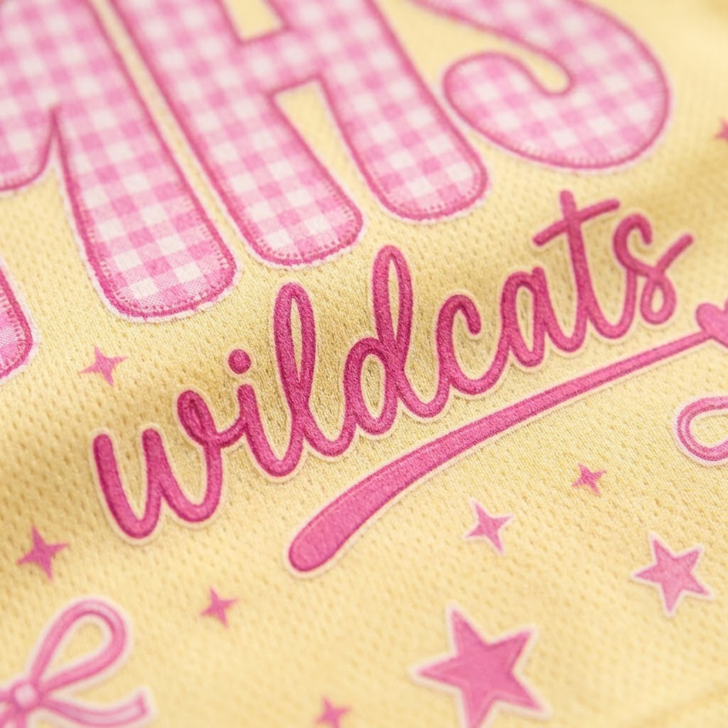 Macro close-up shot of the graphic print on mesh fabric, focusing on the high-definition textures of the pink gingham plaid letters, faux-stitched edges, and ribbon bow.