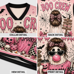 A four-panel collage showing a pink Halloween-themed V-neck jersey from multiple angles: collar detail, back detail, hem detail, and print detail. The design includes dripping 'BOO CREW' lettering, spiderwebs, skulls, pumpkins, bats, a witch figure, and a clown face with heart-shaped sunglasses and a pink bubblegum bubble.