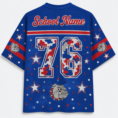 A royal blue short-sleeve t-shirt shown from the back, featuring a customizable 'School Name' text at the collar, a large number '76' filled with a red, white, and blue camouflage pattern, and a bulldog mascot graphic near the bottom. The sleeves have red and white stripes with bulldog head graphics, and the entire shirt is decorated with white stars and silver glitter dots.