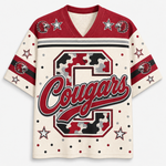 A short-sleeve V-neck athletic jersey with a cream base, red shoulders, and a large camouflage-style letter C with the word 'Cougars' across the front. The sleeves have red and black stripes, white stars, and cougar head logos.