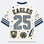 A white athletic-style jersey shown from the back, featuring navy and gold lettering that reads "EAGLES," large number 25 in a blue-and-white gingham pattern, football motifs on the sleeves, stars, stripes, and a feather graphic. No person or real environment is present, so this is Product/Packaging.