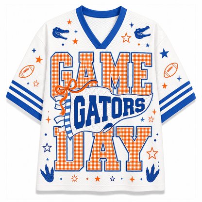 A white mesh short-sleeve V-neck jersey with blue trim and orange/blue 'GAME GATORS DAY' text, decorated with gingham letters, blue gators, footballs, stars, and stripes.