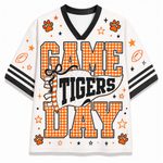 A white mesh short-sleeve t-shirt with a black V-neck collar and sleeve stripes, featuring a 'GAME TIGERS DAY' graphic print in orange and black with paw prints and stars.