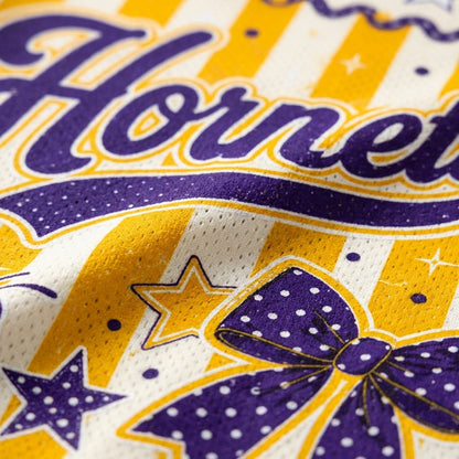 Macro close-up shot of the sublimation printing on the Hornets jersey, emphasizing the breathable mesh texture, script font, and purple polka-dot bow.