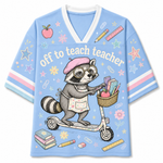 A light blue V-neck t-shirt featuring a cartoon illustration of a raccoon on a scooter with school supplies, and the text 'off to teach teacher' across the front.