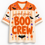 A short-sleeve V-neck football-style shirt with orange and cream panels, decorated with Halloween graphics including bats, stars, stripes, and the text 'second grade BOO CREW' on the front.