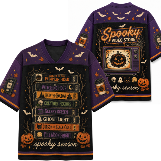 A purple short-sleeve V-neck T-shirt shown from both front and back, featuring a Halloween-themed graphic print with pumpkins, bats, spiderwebs, book spines, ghosts, and the text 'Spooky Video Store' and 'spooky season'.