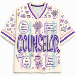 A cream-colored short-sleeve V-neck jersey-style top with purple and pink trim, decorated with pastel illustrations and the word 'COUNSELOR' in large purple letters across the front.