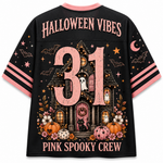A black short-sleeve graphic T-shirt shown from the back, featuring a large pink '31' over a haunted house illustration with ghosts, pumpkins, stars, bats, and the text 'HALLOWEEN VIBES' and 'PINK SPOOKY CREW'. The shirt has pink collar and sleeve trim, and pink-and-black striped sleeve bands.