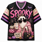 A black short-sleeve V-neck jersey-style top with a colorful Halloween graphic. The front features the word 'Spooky' in large pink letters, a ghost wearing sunglasses and a leopard-print bow, pumpkins, spiderwebs, bats, stars, and a quilted handbag.