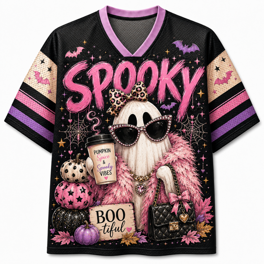 A black short-sleeve V-neck jersey-style top with a colorful Halloween graphic. The front features the word 'Spooky' in large pink letters, a ghost wearing sunglasses and a leopard-print bow, pumpkins, spiderwebs, bats, stars, and a quilted handbag.
