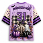 A light purple short-sleeve jersey-style shirt shown from the back, featuring a Halloween-themed graphic with the words 'SPOOKY MOO-CREW,' the number 31, pumpkins, flowers, a witch hat, a ghost, and black-and-white plaid. The sleeves are cream with purple and black stripes.