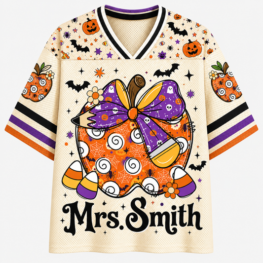 A Halloween-themed V-neck t-shirt with a cream-colored mesh base, featuring a large orange and purple witch's hat graphic, candy corn, bats, pumpkins, and the text 'Mrs. Smith' printed on the front.
