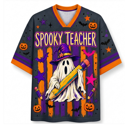 A dark gray V-neck short-sleeve jersey with orange trim and a colorful Halloween graphic featuring the words 'SPOOKY TEACHER,' a ghost, a witch hat, pumpkins, bats, stars, and pencils.