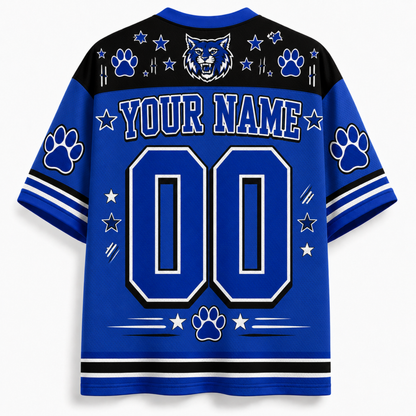Customizable royal blue and black short-sleeve athletic jersey shown from the back, featuring a large 'YOUR NAME' and '00' placeholder design with paw prints, stars, stripes, and a wolf head graphic on the shoulders.