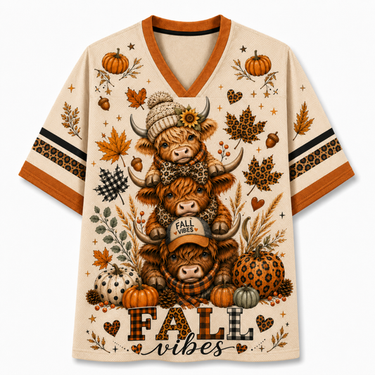 Front view of the cream varsity mesh jersey displaying three stacked cute highland cows wearing beanie and cap, leopard pumpkins, and Fall Vibes typography.