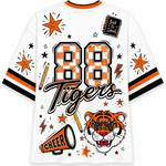 White short-sleeve t-shirt with orange and black graphic designs, featuring the number 88, 'Tigers' script, a tiger illustration, stars, lightning bolts, a megaphone, and a 'Back to School' notebook graphic.