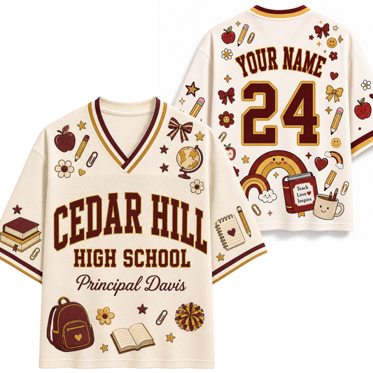 A cream-colored mesh sports jersey shown from both the front and back, featuring 'CEDAR HILL HIGH SCHOOL' and 'Principal Davis' on the front, with customizable 'YOUR NAME' and '24' on the back. The jersey is decorated with school-themed illustrations including a rainbow, backpack, books, and stars in maroon and brown.