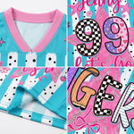 A close-up collage of a children's sports jersey showing the front collar, sleeve cuff, and decorative printed panels. The jersey is turquoise and pink with white polka-dot and striped accents, plus large graphic numbers and lettering in pink, black, white, and orange.