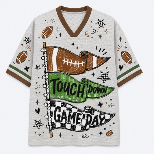 A short-sleeve V-neck athletic-style shirt with a white mesh-like base and brown trim, decorated with football motifs and the words 'TOUCH DOWN GAME DAY' across two pennants. The shirt is shown flat against a light gray background.