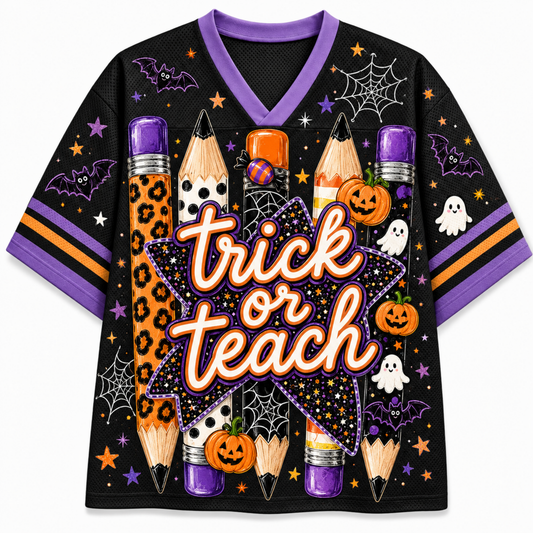 A black short-sleeve V-neck t-shirt with a purple collar, featuring a Halloween-themed graphic print with the words 'trick or teach' in orange and white script. The design includes orange leopard-print pencils, jack-o'-lanterns, ghosts, bats, spiderwebs, and stars on a white background.