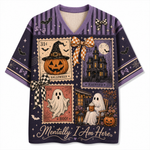 A purple short-sleeve V-neck t-shirt with a detailed Halloween collage print on the front, featuring vintage-style stamps, a haunted house, a jack-o'-lantern, ghosts, bats, and the text 'Mentally I Am Here.'.