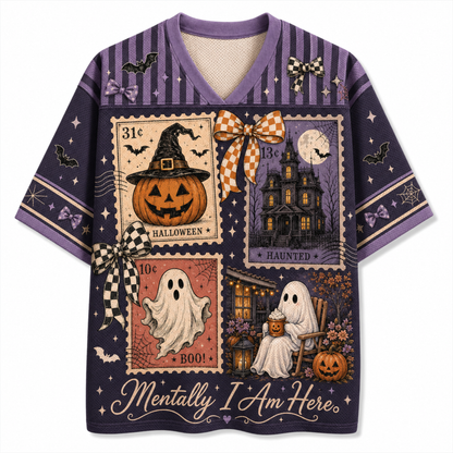 A purple short-sleeve V-neck t-shirt with a detailed Halloween collage print on the front, featuring vintage-style stamps, a haunted house, a jack-o'-lantern, ghosts, bats, and the text 'Mentally I Am Here.'.