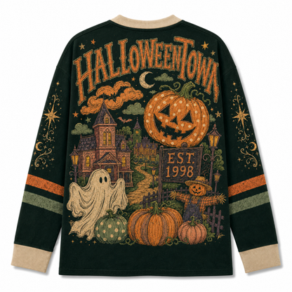 A dark green long-sleeve crewneck sweatshirt shown from the back, featuring a large, detailed Halloween-themed graphic print with 'HALLOWEENTOWN' text, a jack-o'-lantern, a haunted house, a ghost, pumpkins, and a scarecrow. The sweatshirt has beige ribbed cuffs and collar, and orange and green stripes on the sleeves.