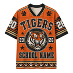An orange short-sleeve athletic-style jersey with a black and white V-neck collar, featuring a tiger graphic, paw prints, and the word 'TIGERS' across the chest. The design includes customizable text placeholders like 'SCHOOL NAME' and numbers '20' and '26'.
