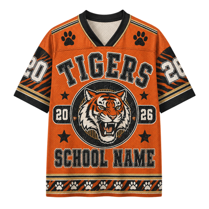 An orange short-sleeve athletic-style jersey with a black and white V-neck collar, featuring a tiger graphic, paw prints, and the word 'TIGERS' across the chest. The design includes customizable text placeholders like 'SCHOOL NAME' and numbers '20' and '26'.