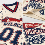 A close-up collage of a cream-colored athletic jersey with navy and red varsity-style graphics, including the word 'WILDCATS,' 'GAME DAY,' stars, a pom-pom graphic, and large number '01' on the front.