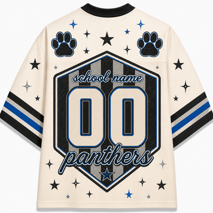 A cream-colored short-sleeve jersey shown from the back, featuring a large black, gray, and blue shield graphic with the text 'school name', '00', and 'panthers'. The jersey is decorated with black paw prints, stars, and blue and black stripes on the sleeves.