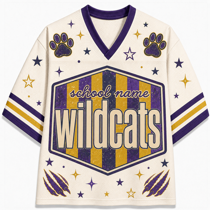 A cream-colored athletic jersey with purple and gold accents, featuring a V-neck, sleeve stripes, paw prints, claw marks, and a central hexagonal patch that reads 'school name Wildcats'.