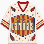 A cream-colored mesh V-neck jersey with red and gold accents, featuring a large central shield graphic that reads 'school name cardinals' and decorative cardinal wings and stars.