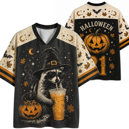A Halloween-themed V-neck t-shirt shown from both front and back. The shirt features a black body with cream-colored sleeves and collar trim, decorated with spooky graphics including a raccoon in a witch hat holding an iced drink, a jack-o'-lantern bucket, bats, crescent moons, stars, and the word 'HALLOWEEN' on the back.