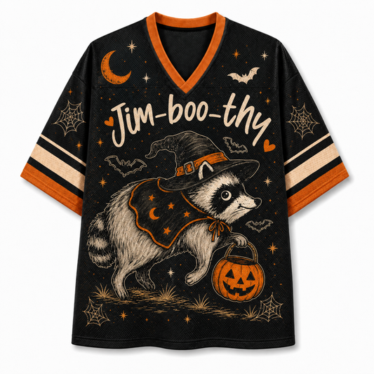 A black V-neck athletic-style T-shirt with orange trim and striped sleeves, featuring a large Halloween graphic of a raccoon in a witch hat holding a jack-o'-lantern, with stars, bats, spiderwebs, and the text 'Jim-boo-thy' across the front.