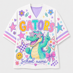 A white short-sleeve V-neck jersey-style shirt with colorful school-themed graphics, including the word "GATORS" in large multicolor letters, a green alligator wearing star-shaped sunglasses, pink bows, stars, flowers, and the text "School name" on a light gray background.